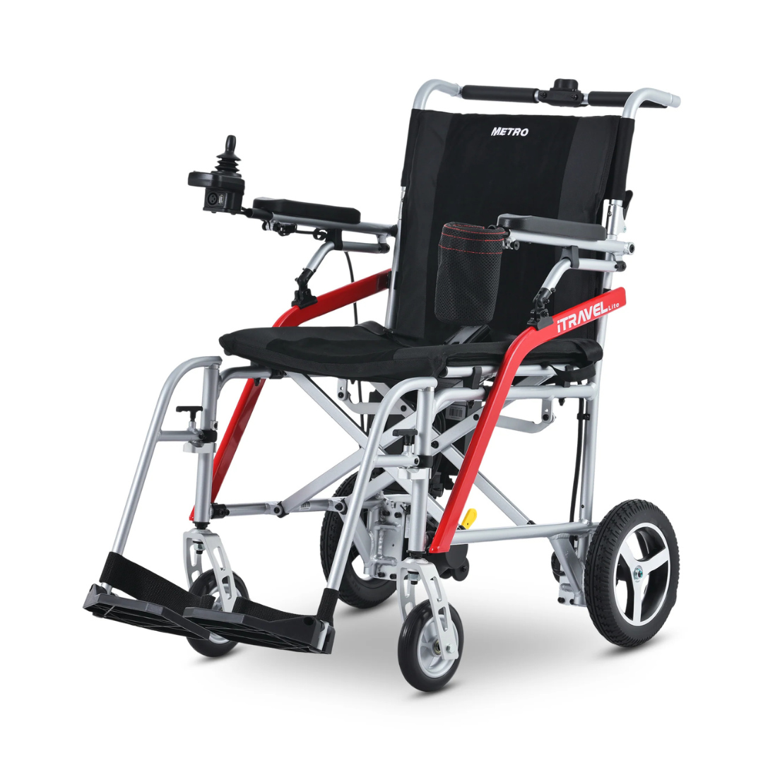 The Metro Mobility iTravel Lite Portable Powerchair features a joystick controller on the armrest, red frame accents, black seat and backrest, footrests, large rear wheels, and is airplane-friendly for easy travel.
